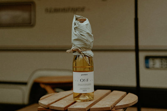Wine bottle wrapped in a cloth on a camping table