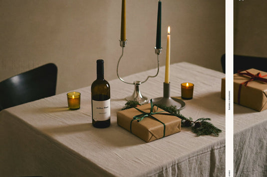 Laid table with candles, a bottle of wine and wrapped gifts