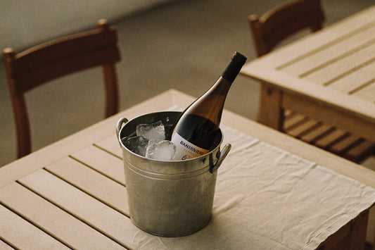 Wine bottle in an ice bucket on a wooden garden table