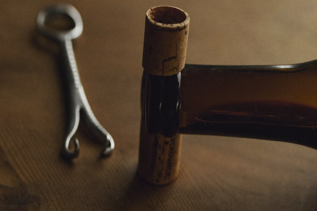 Cork and corkscrew beside an opened bottle of wine